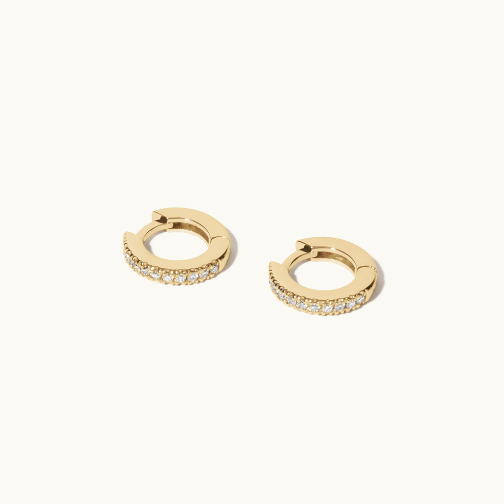 Angled view of Jewellers District's Petite Diamond Hoop Earrings in 14k Yellow Gold