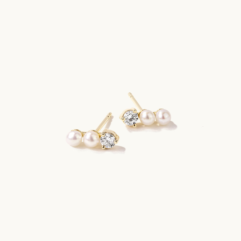 Angled view of Jewellers District's Three-Stone Pearl and Diamond Bar Earrings in 14k Yellow Gold