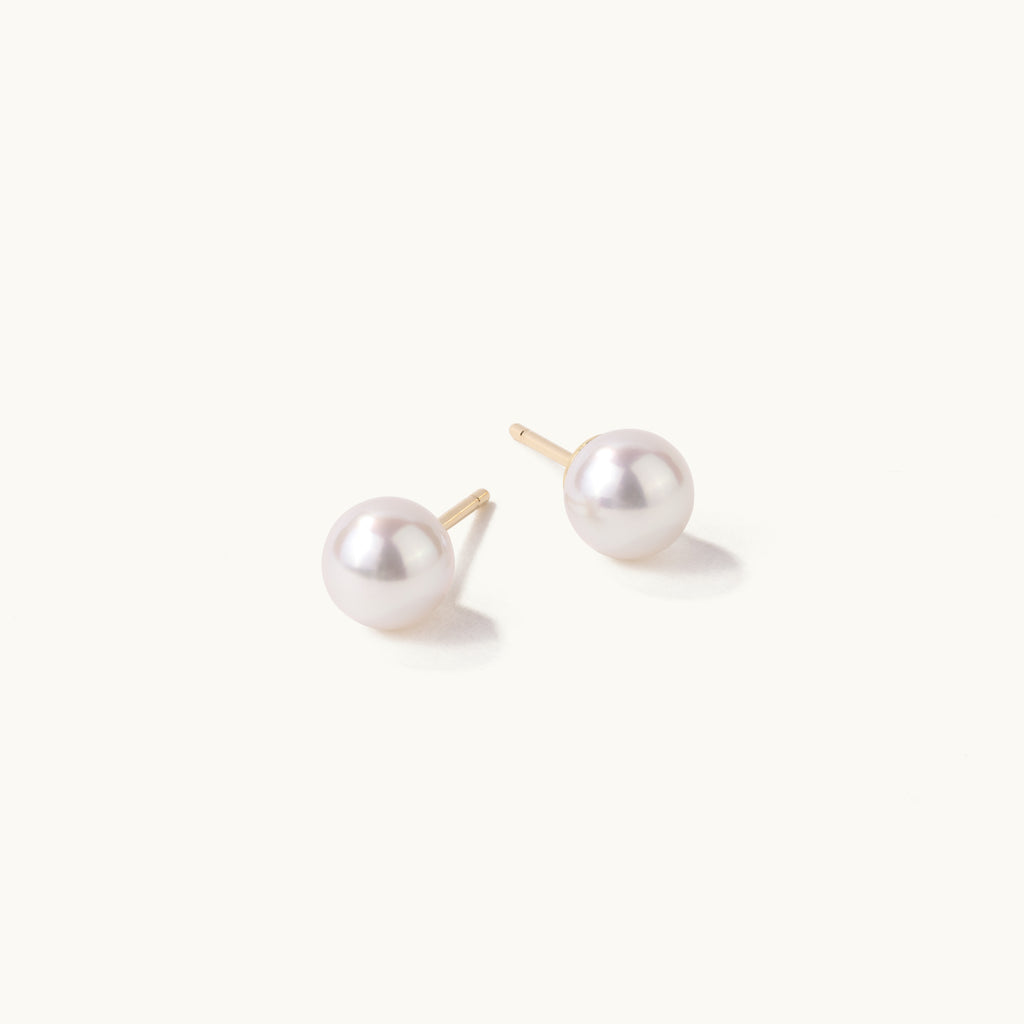 Angled view of Jewellers District's Freshwater Pearl Stud Earrings in 14k Yellow Gold