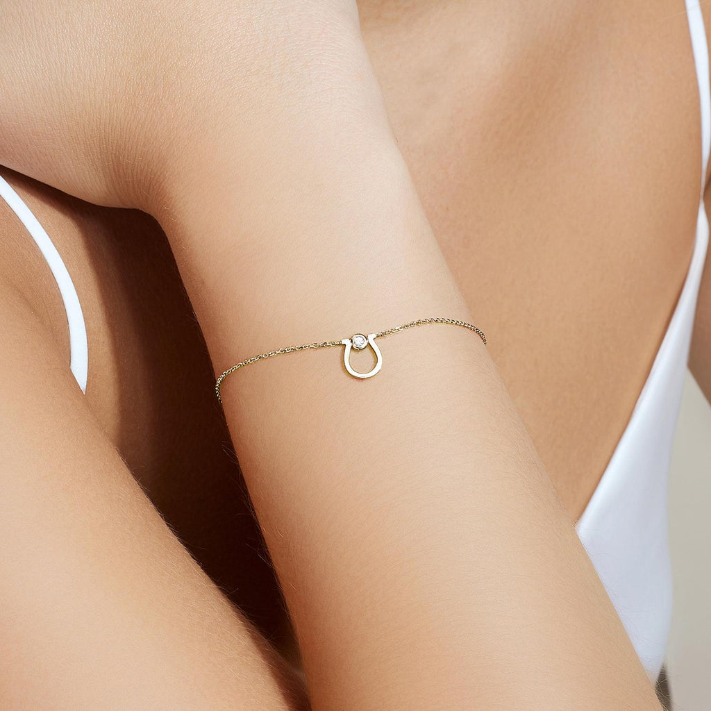 Model wearing Jewellers District's Gold Horseshoe Chain Bracelet with Diamond in 10k Yellow Gold