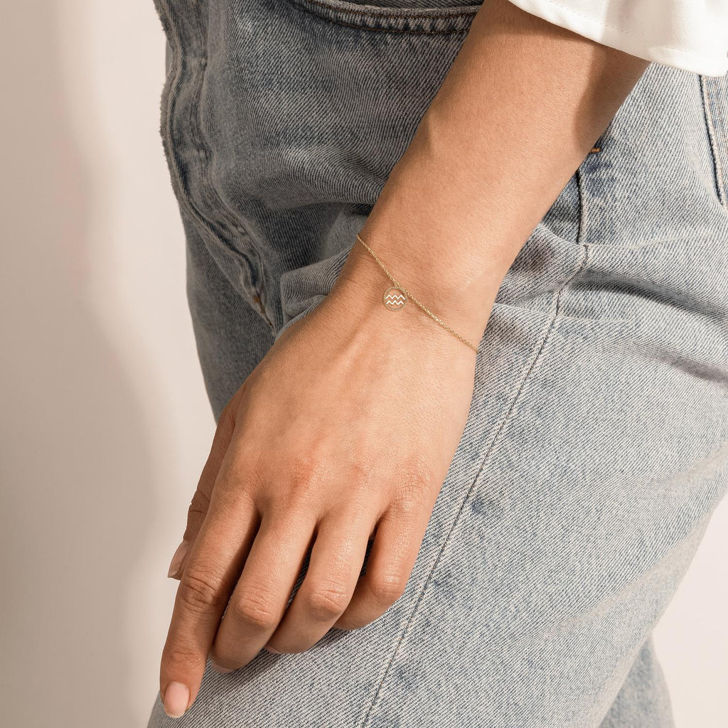 Model wearing Jewellers District's Gold Zodiac Charm Bracelet: Aquarius in 14k Yellow Gold #3