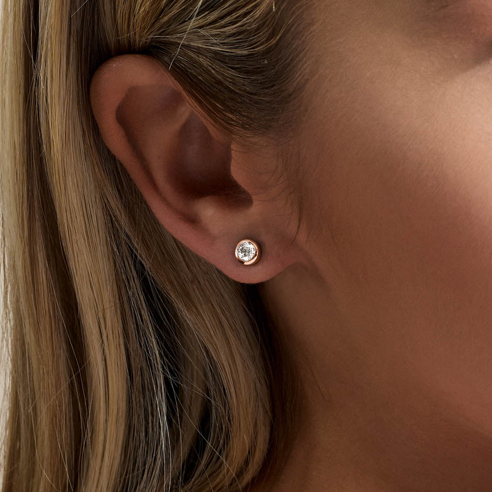 Model wearing Jewellers District's Bold Bezel-Set Round Cut Diamond Studs in 10k Rose Gold #4