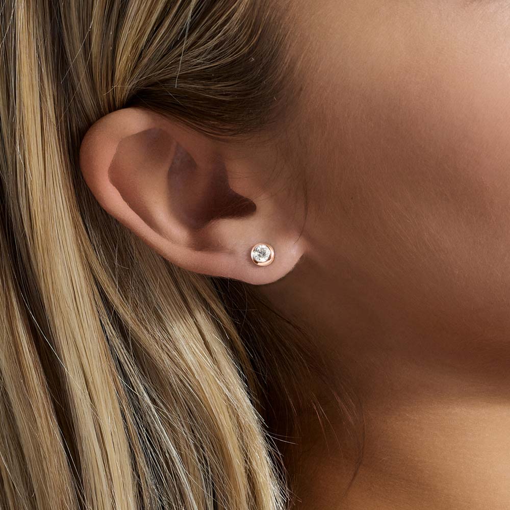 Model wearing Jewellers District's Bold Bezel-Set Round Cut Diamond Studs in 10k Rose Gold #3