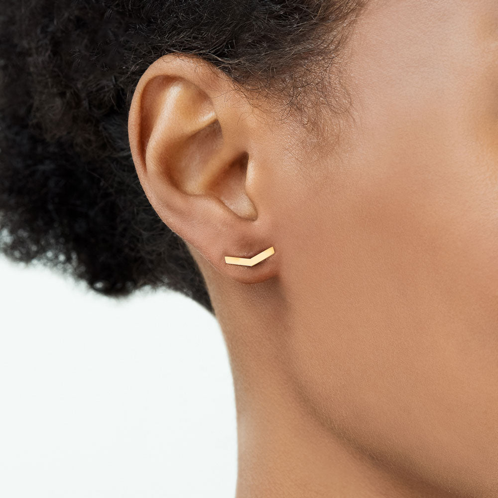 Model wearing Jewellers District's V-Shaped Gold Stud Earrings in 10k Yellow Gold #3