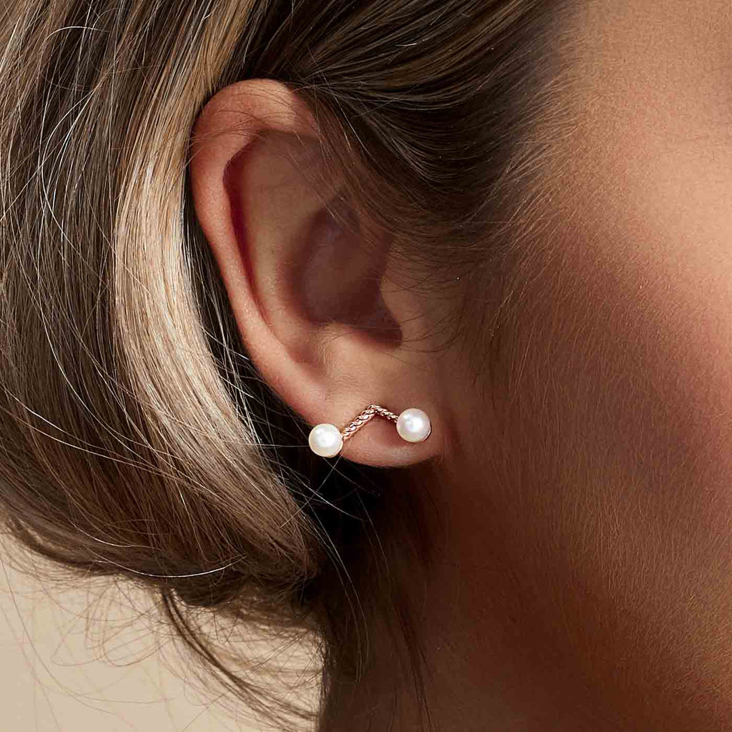 Model wearing Jewellers District's Cherry Stem Freshwater Pearl Earrings in 14k Rose Gold