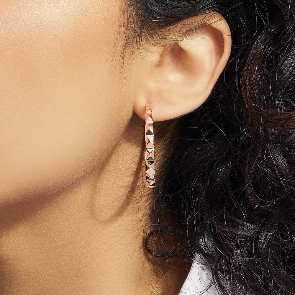 Model wearing Jewellers District's Faceted Gold Hoop Earrings in 14k Rose Gold #2