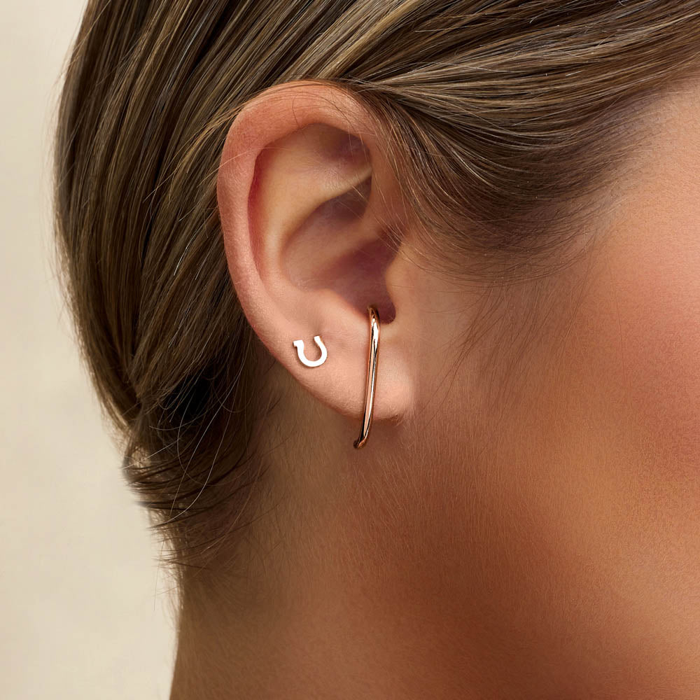 Model wearing Jewellers District's Gold Horseshoe Stud Earrings in 10k Rose Gold #3