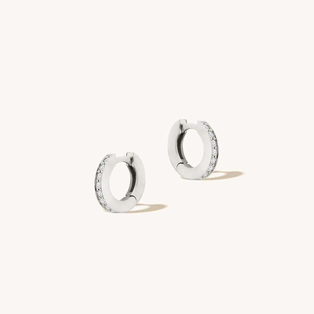 Angled view of Jewellers District's Diamond Hoop Earrings with Bright-Cut Setting in 10k White Gold