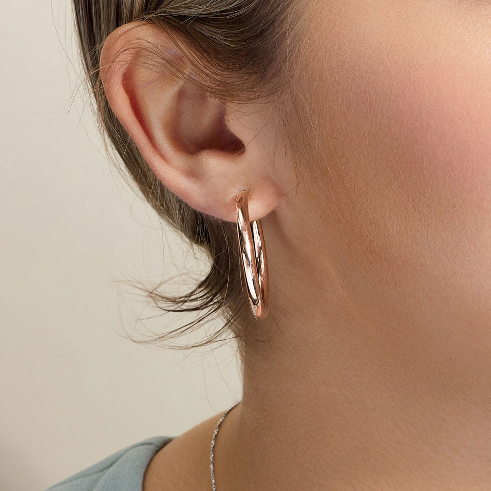 Model wearing Jewellers District's Gold Hoop Earrings in 10k Rose Gold