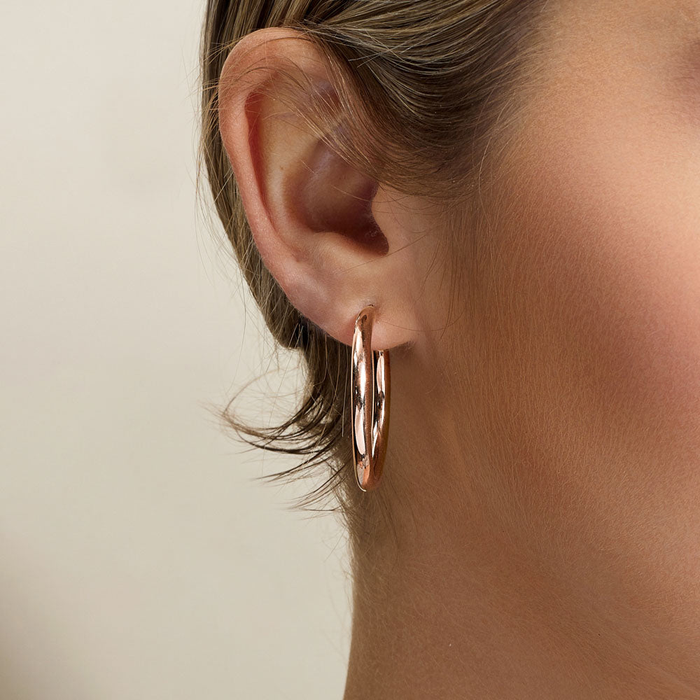 Model wearing Jewellers District's Gold Hoop Earrings in 10k Rose Gold #2