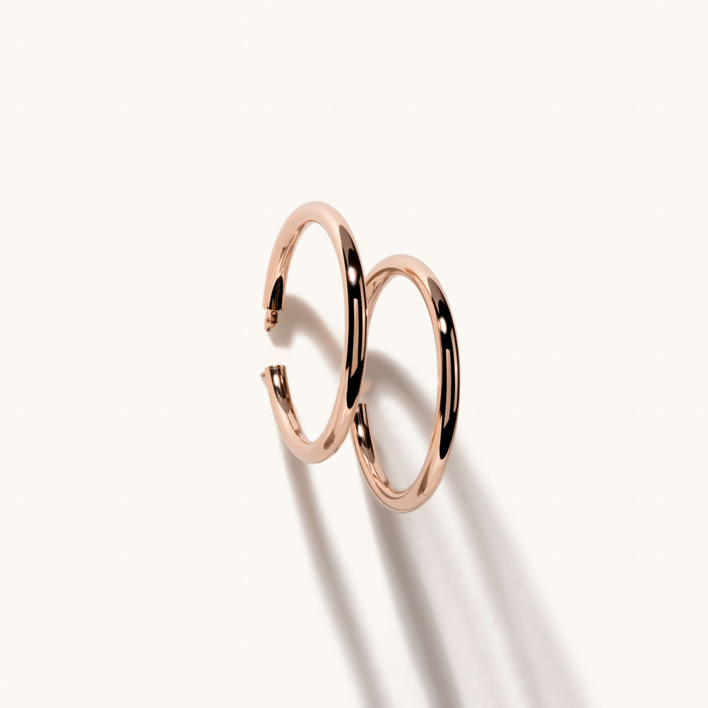 Angled view of Jewellers District's Thin Gold Hoop Earrings in 14k Rose Gold