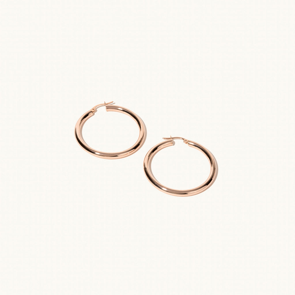 Profile view of Jewellers District's Thin Gold Hoop Earrings in 14k Rose Gold