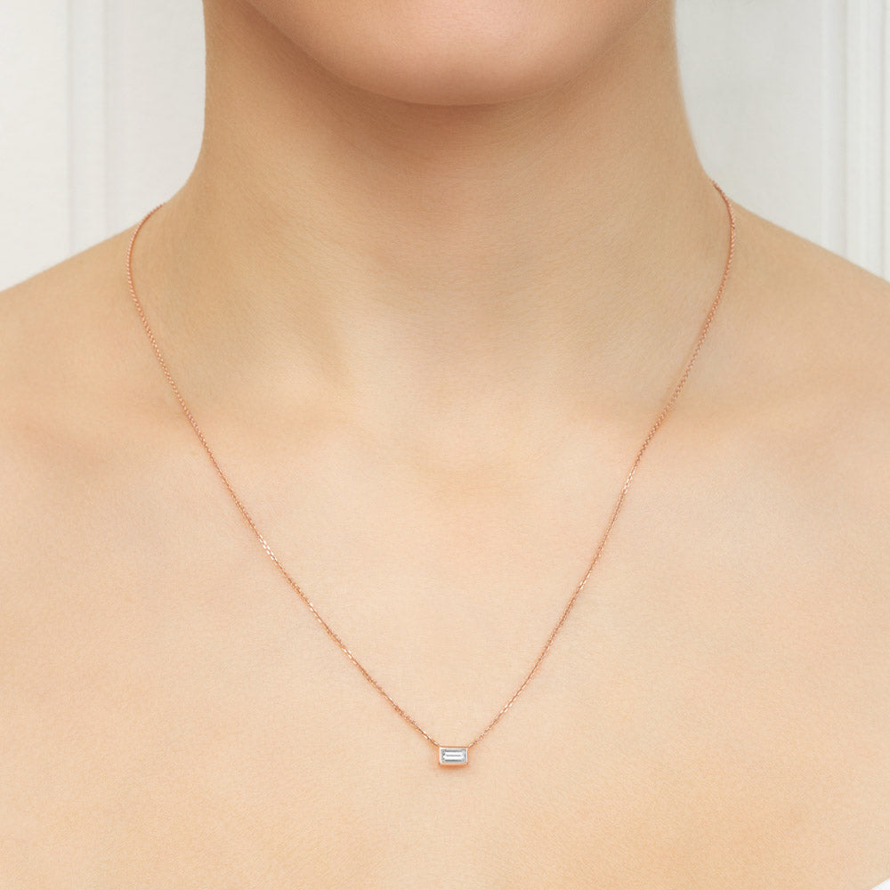 Model wearing Jewellers District's Baguette-Cut Bezel-Set Diamond Pendant Necklace in 10k Rose Gold