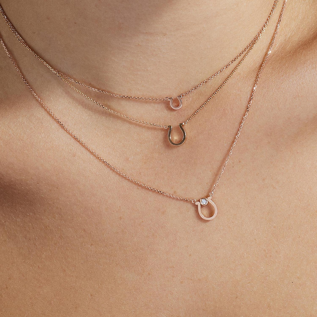 Model wearing Jewellers District's Petite Gold Horseshoe Pendant Necklace in 14k Rose Gold