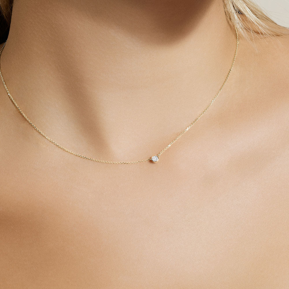 Model wearing Jewellers District's Bezel-Set Solitaire Diamond Necklace in 10k Yellow Gold #2