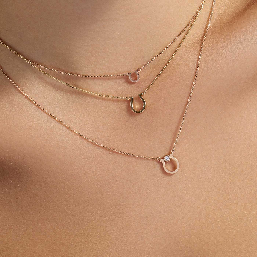 Model wearing Jewellers District's Gold Horseshoe Pendant Necklace in 14k Rose Gold