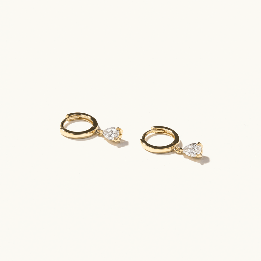 Profile view of Jewellers District's Gold Hoop Earrings with Pear Cut Diamond Charm in 14k Yellow Gold